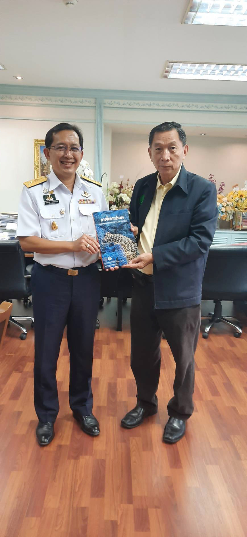 นายเฉลิมชัย สุวรรณรักษ์ อธิบดีกรมประมง ให้การต้อนรับ นายนิวัติ สุธีมีชัยกุล อดีตอธิบดีกรมประมง ซึ่งได้นำตำรา เรื่อง 